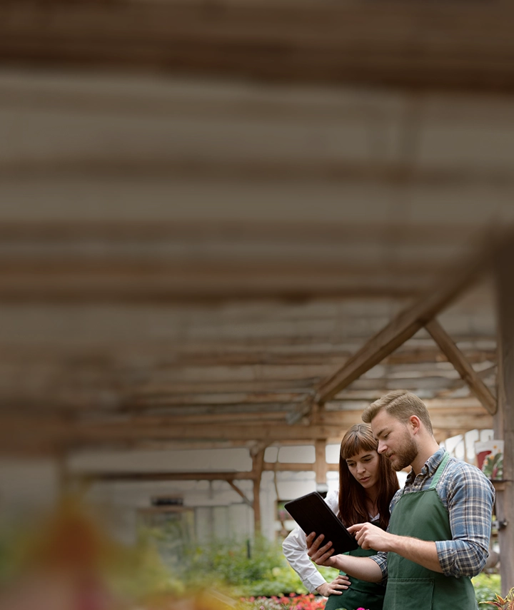 A woman and a man speaking while reviewing something on a tablet