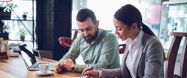 A man and a woman having a discussion at a desk