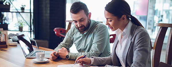 A woman and a woman having a discussion at a table